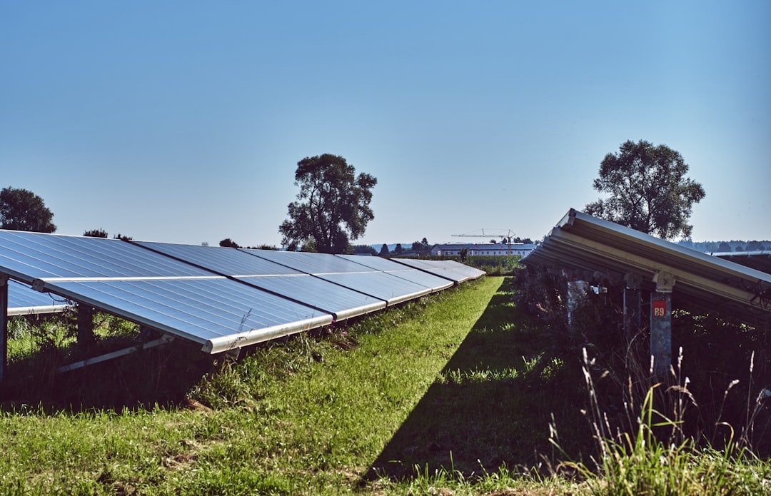 black-solar-panels-on-green-grass-field-under-blue-sky-during-daytime-mdyoazblyhu