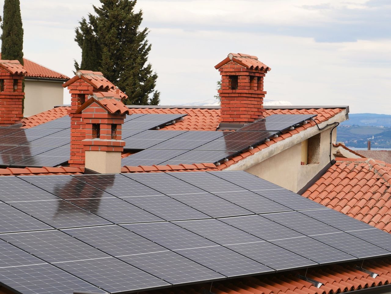 Crafting Captivating Headlines: Your awesome post title goes here Solar panels on tiled roofs of houses with chimneys, capturing clean energy.